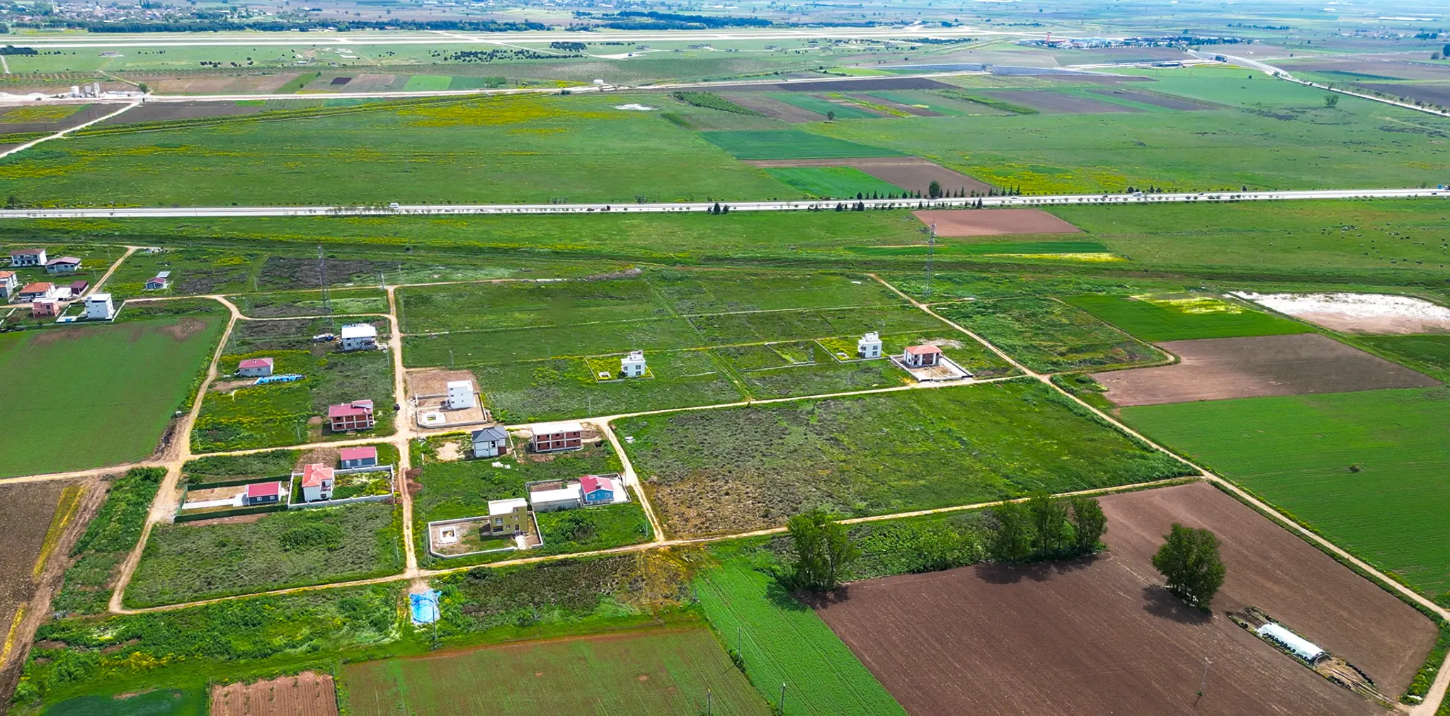 Bursa Yenişehir Karaköy'deki yatırım arsalarının, Yenişehir Havalimanı'na olan komşu konumunu gösteren panoramik drone görüntüsü.