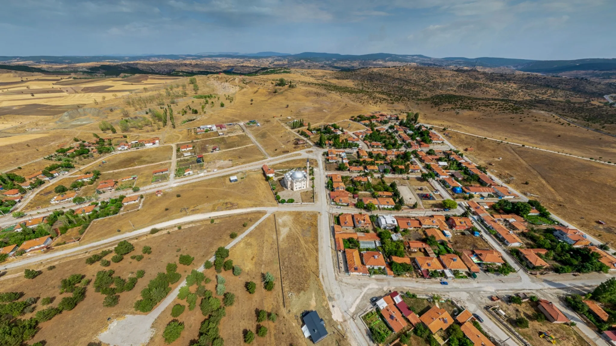 Seyitömer'deki iş alanlarına yakınlığıyla kira geliri potansiyeli sunan arsa yatırımının drone görseli.