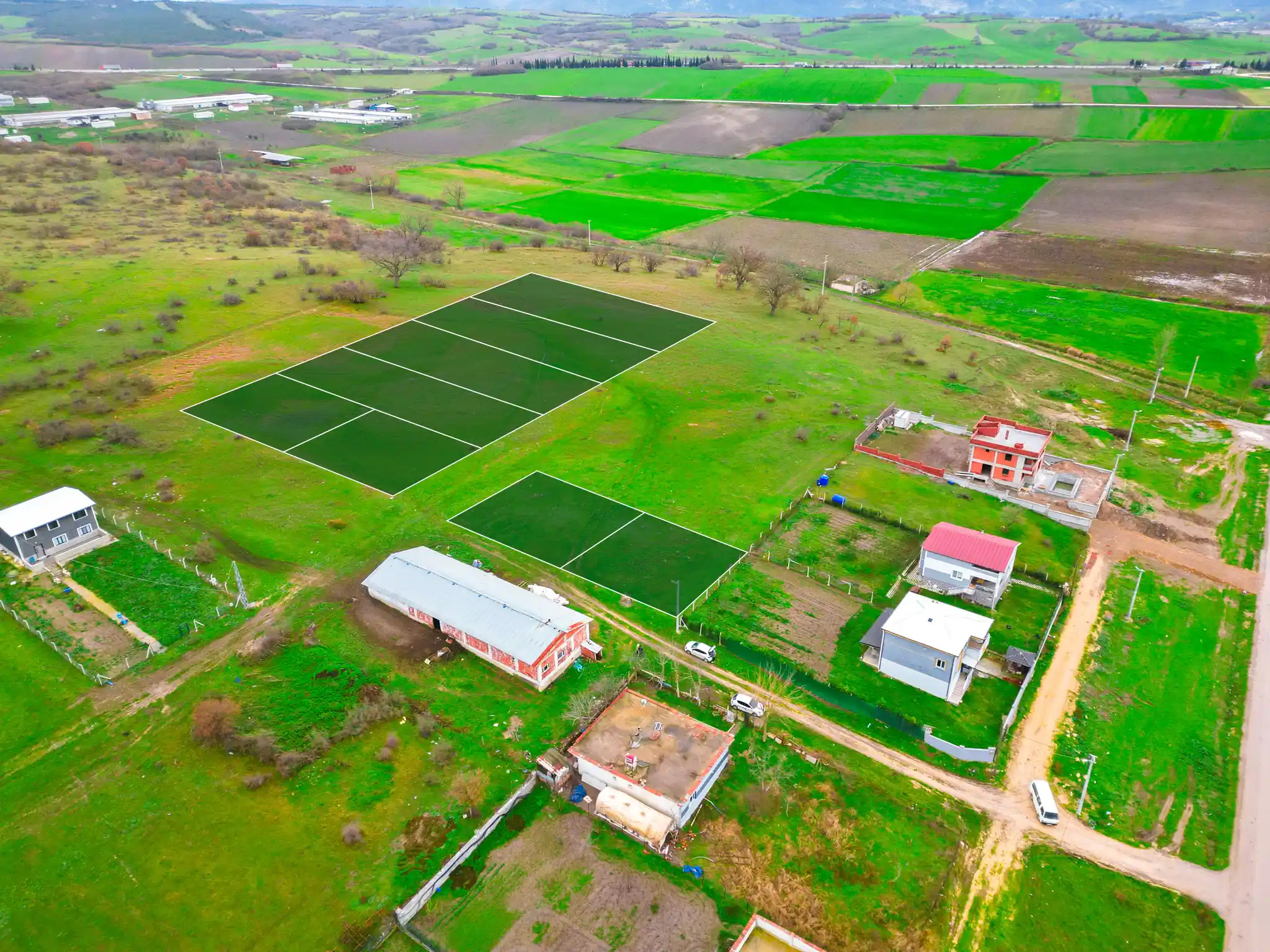 Belirlenmiş arsa sınırlarını, köşe kazıklarını ve çevre düzenlemesini gösteren saha görseli.