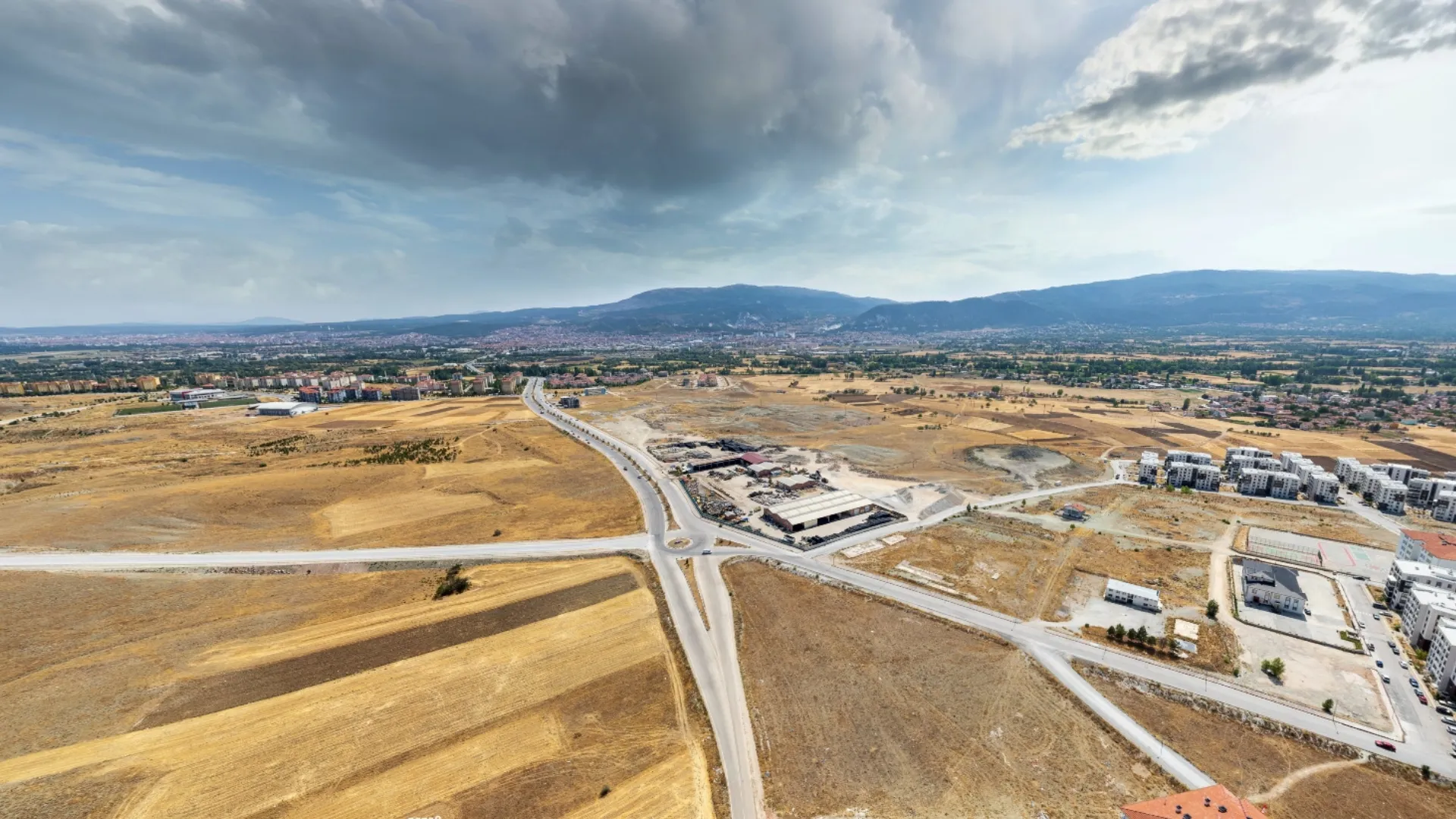 BT Çinikent konut projesi arazisinin güney cephesinden çekilmiş geniş açılı drone fotoğrafı, arazinin topografyası ve güneş alma potansiyeli.