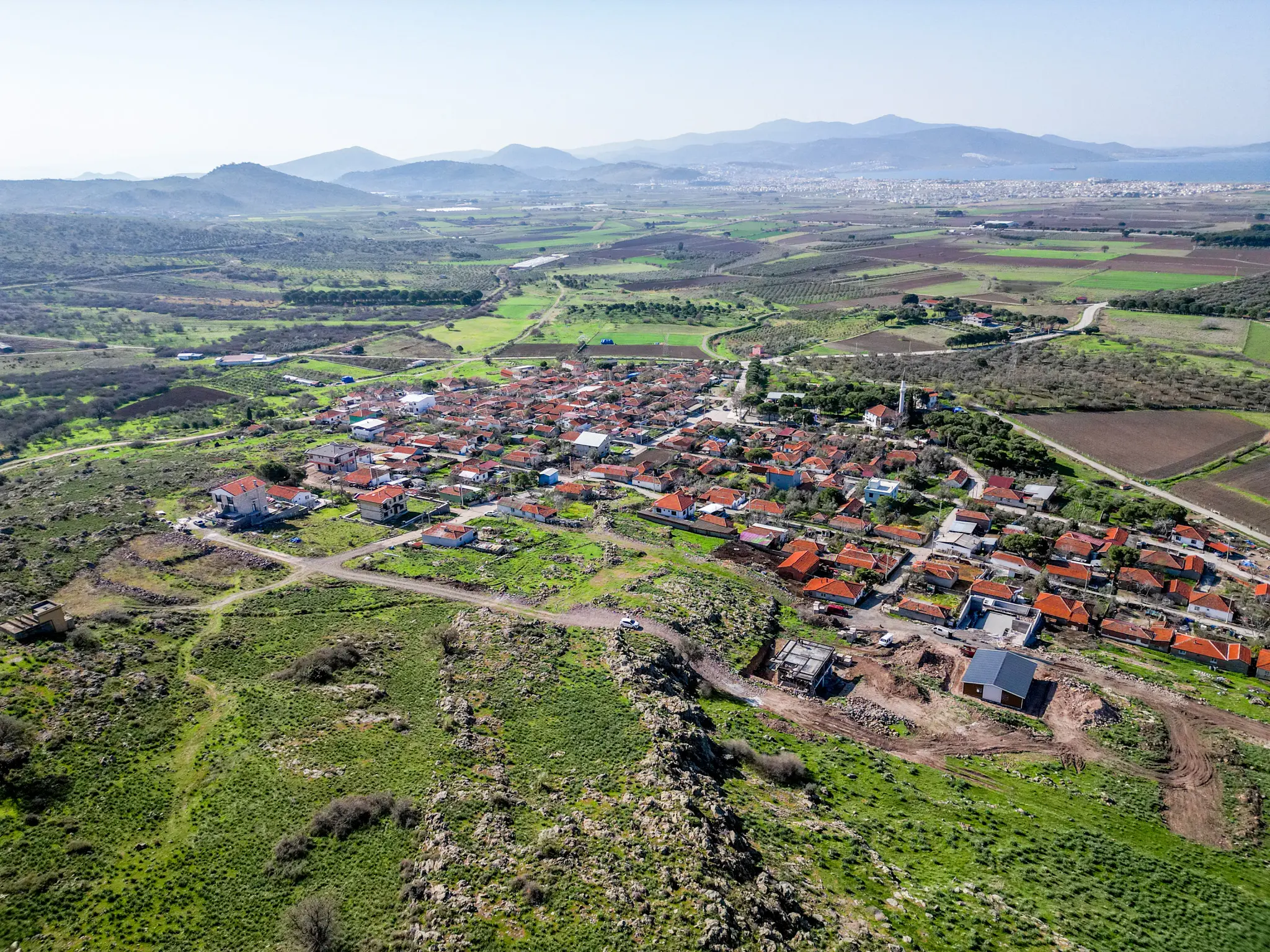 Aqua Dikili projesinde, zeytin ağaçları arasında yer alan, yatırıma hazır imarlı bir arsa parseli.