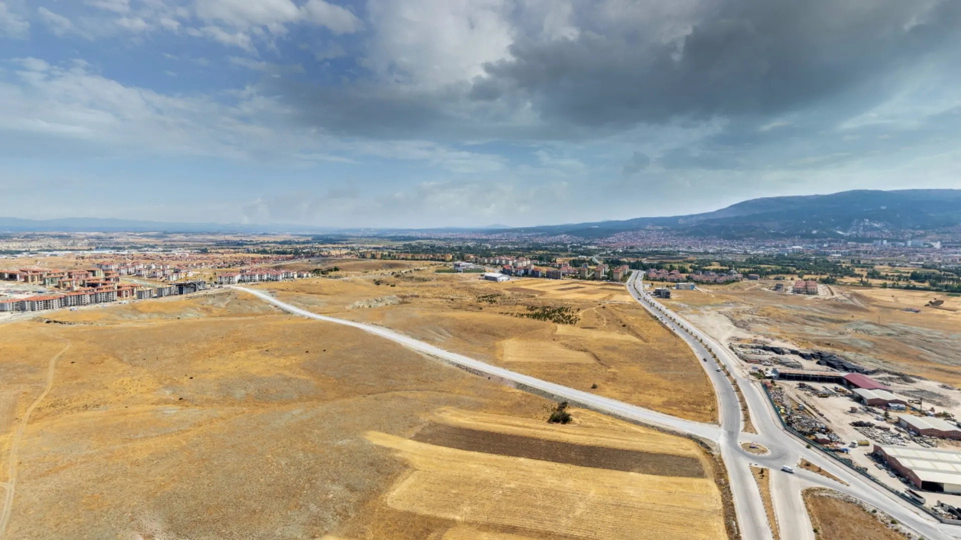 Gün batımında BT Çinikent proje arazisi, şehrin ışıkları ve gelecekteki konutların sahip olacağı manzarayı gösteren etkileyici drone çekimi.